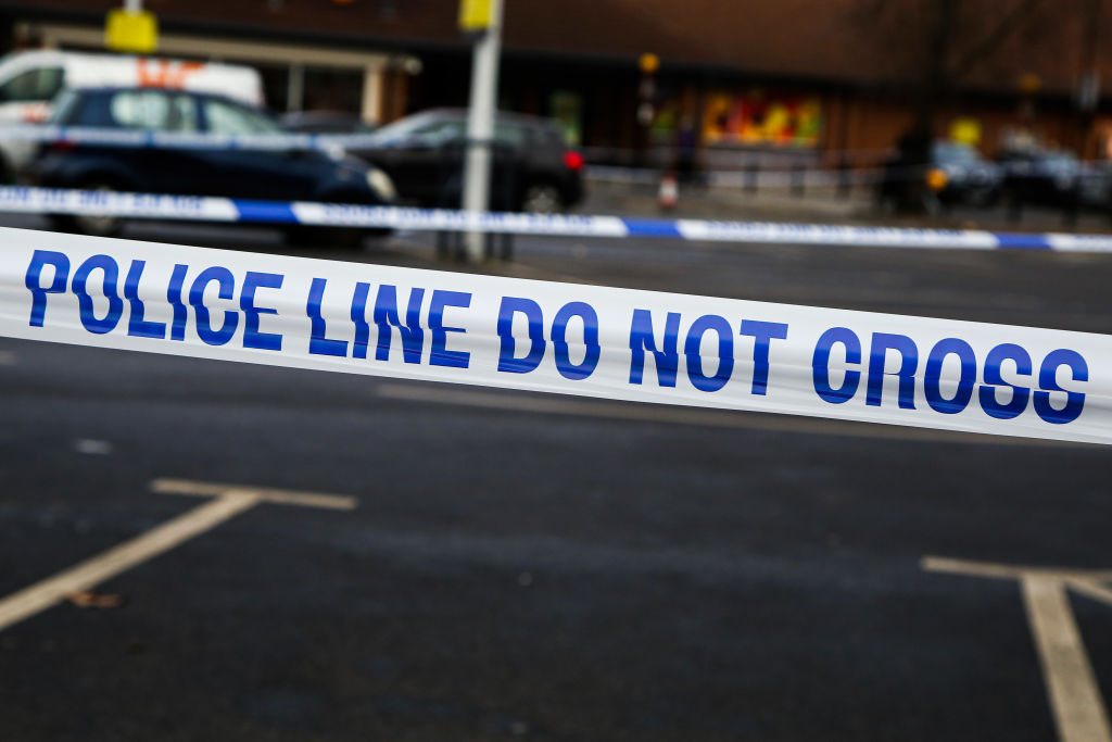 A police tape is attached surrounding a crime scene in...