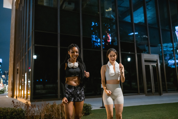 Two friends filming a fun dance video together after their workout session